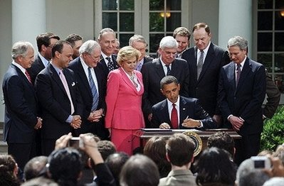 US President Barack Obama signs the Credit Card Accountability, Responsibility and Disclosure (CARD) Act, surrounded by lawmakers, in the Rose Garden at the White House. Obama Friday signed sweeping credit card reforms into law, aiming to shield consumers from predatory fees and shock rate hikes, despite complaints from the industry. (AFP/Nicholas Kamm)