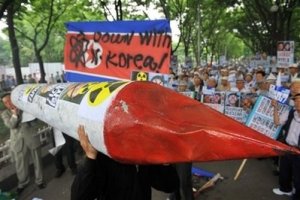 South Korean protesters carry a mock missile along with a defaced North Korean flag in Seoul on June 15. The communist North has described itself as a "proud nuclear power" and has threatened to hit back if attacked, as the United States tracked one of its ships on suspicion it is carrying a banned weapons cargo. (AFP/File/Kim Jae-Hwan)
